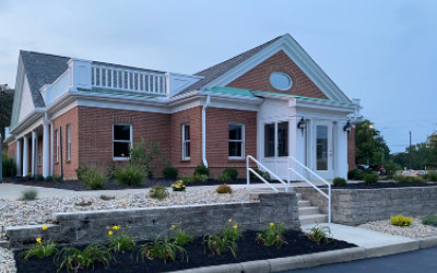 Professional team of six standing in front of Horvath Vision Care sign.