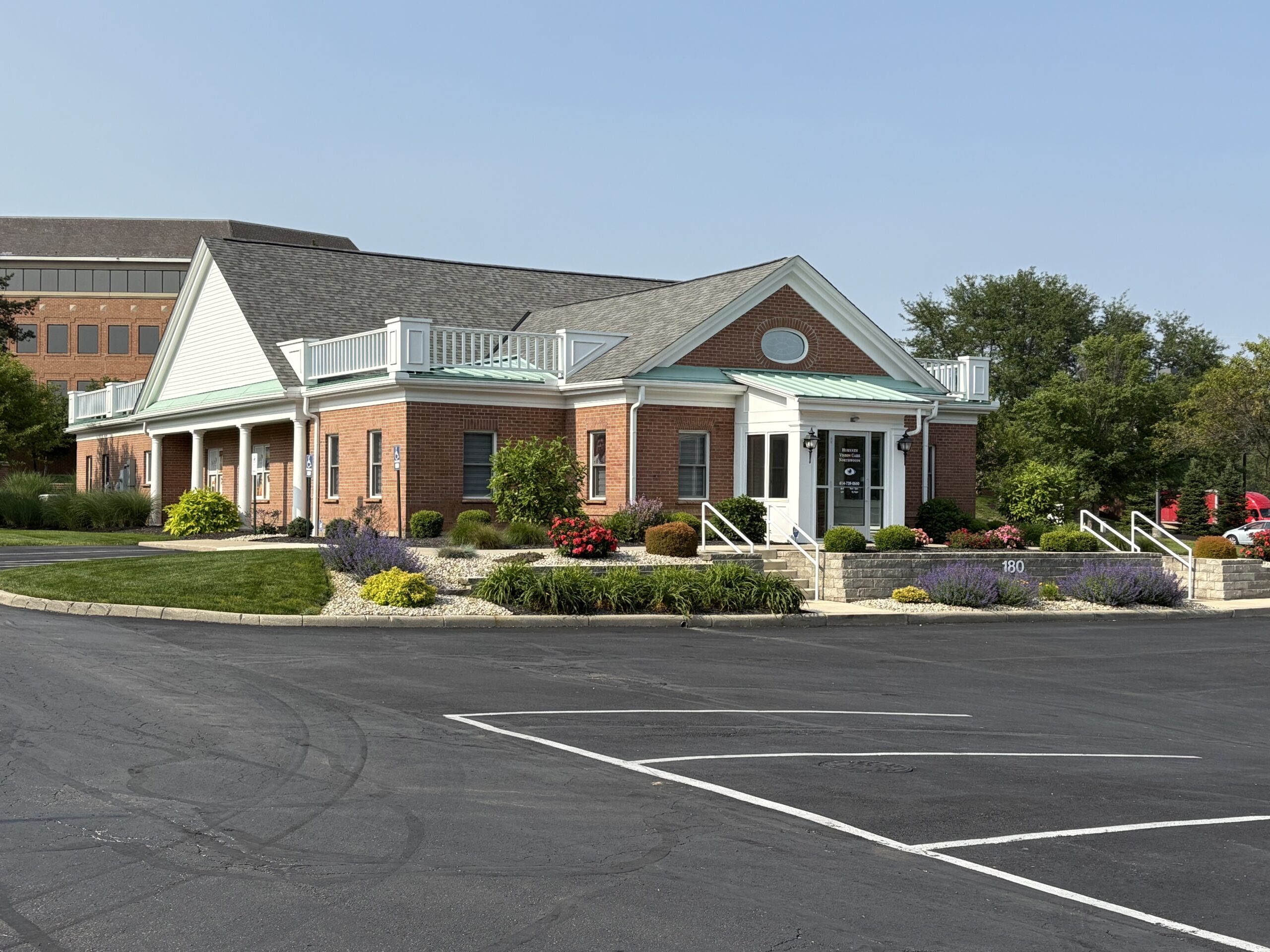 A brick building with well-maintained landscaping and empty parking spaces.